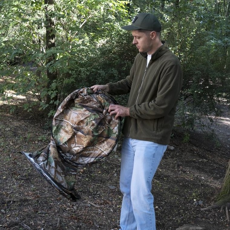 Shower tent folded down into its compact disc shape